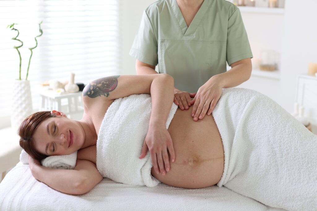 Woman receiving a prenatal massage from massage therapist at Equilibrium Therapeutics