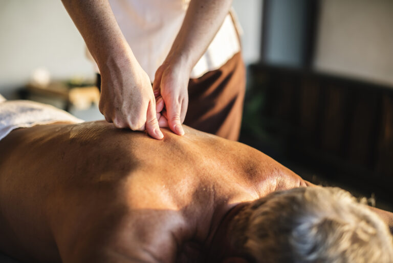 A mature male active adult finds relief for his sore muscles with a massage at Equilibrium Therapeutics.